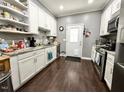 Well-lit kitchen featuring white cabinetry, granite countertops, stainless steel appliances, and hardwood flooring at 4057 Old Franklinton Rd, Franklinton, NC 27525