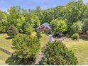 Aerial view of a brick home with extensive lawn, mature trees, and private driveway at 412 Bowen Rd, Rougemont, NC 27572