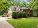Well-maintained brick home featuring a three-car garage and meticulously manicured lawn with verdant landscaping at 4505 Wood Valley Dr, Raleigh, NC 27613