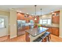 Modern kitchen featuring stainless steel appliances, a center island with seating, and hardwood floors at 457 S Greensboro St, Carrboro, NC 27510