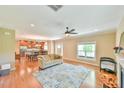 Open-concept living room featuring hardwood floors, a ceiling fan, and seamless connection to the dining area and kitchen at 457 S Greensboro St, Carrboro, NC 27510