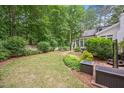 Lush backyard featuring mature trees and landscaping with a charming white picket fence at 5241 Mill Dam Rd, Wake Forest, NC 27587