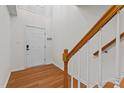 Bright foyer with wood floors, stairs, a coat closet, and a white front door at 5310 Echo Ridge Rd, Raleigh, NC 27612