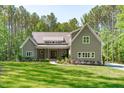 Charming craftsman-style home with a well-manicured lawn and beautiful landscaping against a backdrop of tall trees at 59 Mill Rd, Pittsboro, NC 27312