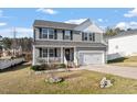 Beautiful two-story home boasts a cozy front porch with comfortable seating, perfect for enjoying quiet mornings at 59 Nevada Ct, Clayton, NC 27527