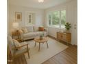 Bright living room with hardwood floors, neutral paint, and large windows offering natural light at 6017 Whitaker Ln, Raleigh, NC 27603