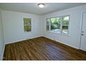 Inviting living room featuring ample natural light, beautiful hardwood floors, and a fresh, neutral color palette at 6017 Whitaker Ln, Raleigh, NC 27603
