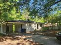 Quaint single-story home with a carport nestled among mature trees, offering shade at 626 Hoover Rd, Durham, NC 27703