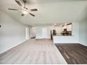Bright open-concept living area featuring a ceiling fan, open kitchen, and neutral tones at 631 Southwick Pl, Mebane, NC 27302