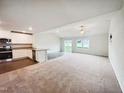 Large living area with a view of the open kitchen, and sliding door access to the backyard at 631 Southwick Pl, Mebane, NC 27302