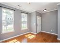 Bright living room featuring gleaming hardwood floors and large windows at 7616 Satinwing Ln, Raleigh, NC 27617