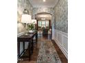 Inviting entryway with hardwood floors, elegant wallpaper, and an arched doorway at 8461 Lentic Ct, Raleigh, NC 27615