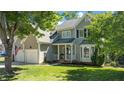 Beautiful two-story home with a well-maintained lawn, an American flag, and a charming porch with white columns at 8724 Deerland Grove Dr, Raleigh, NC 27615