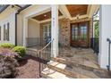 Inviting front porch featuring stone accents, wood columns, and a stylish entrance with double doors at 937 Sedgefield Park Ln, Cary, NC 27519