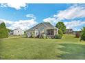 Expansive backyard with a well-maintained lawn, mature trees, and a screened-in porch perfect for outdoor living at 95 Live Oak Dr, Louisburg, NC 27549