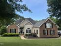 Charming home boasts a manicured lawn, black shutters, and lush landscaping at 95 Live Oak Dr, Louisburg, NC 27549