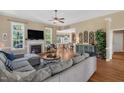 Spacious living room featuring a cozy fireplace, ceiling fan, and windows providing natural light at 95 Live Oak Dr, Louisburg, NC 27549