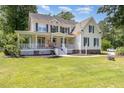 Two-story home with a welcoming front porch and well-manicured lawn, shaded by mature trees at 101 Rainbow Dr, Carrboro, NC 27510