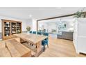 Open concept dining room with wooden table, bench, and blue velvet chairs at 102 Lake Dr, Wendell, NC 27591