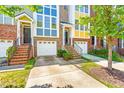 Brick townhome with garage, green yard, and a welcoming entrance at 1028 Summerhouse Rd, Cary, NC 27519
