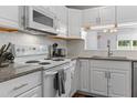 Bright kitchen with white cabinets, granite countertops, white appliances, and subway tile backsplash at 11 Providence Ct, Durham, NC 27705