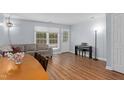 Spacious living room with wood floors, and a piano and large window with a view of greenery at 11 Providence Ct, Durham, NC 27705