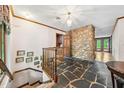 Unique foyer features a stone accent wall, slate flooring, and stairs to the basement at 11009 Eaglerock Dr, Raleigh, NC 27613