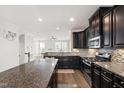 Stylish kitchen with granite island and countertops, stainless steel appliances, and dark wood cabinetry at 1101 Boxcar Way, Apex, NC 27502