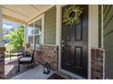 Inviting front porch with dark front door adorned with a floral wreath at 1103 Capstone Dr, Durham, NC 27713