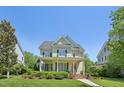 Inviting two-story home with a classic yellow exterior, covered front porch, and well-manicured landscaping at 1104 Dominion Hill Dr, Cary, NC 27519