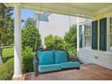 Relaxing porch swing with plush cushions, set against a backdrop of lush greenery and the home's exterior at 1104 Dominion Hill Dr, Cary, NC 27519