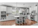Bright kitchen featuring white cabinets, a center island with seating, and stainless steel appliances at 1401 Everette Fields Rd, Morrisville, NC 27560
