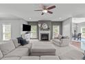 Spacious living room featuring a fireplace, plush seating, neutral tones, and a ceiling fan at 1401 Everette Fields Rd, Morrisville, NC 27560
