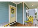 Inviting front porch featuring a cheerful yellow door and comfortable seating area at 1448 Big Falls Dr, Wendell, NC 27591