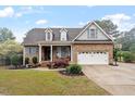 Charming brick home featuring dormer windows, shutters, attached garage with basketball hoop, and lush landscaping at 151 Donnibrook, Fuquay Varina, NC 27526