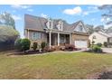 Charming brick home featuring dormer windows, shutters, attached garage with basketball hoop, and manicured front yard at 151 Donnibrook, Fuquay Varina, NC 27526