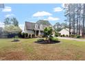 Well-maintained brick home with dormer windows, blue shutters, manicured landscaping, and a spacious front yard at 151 Donnibrook, Fuquay Varina, NC 27526