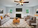 Bright, staged living room with fireplace, ceiling fan, and natural light from the windows at 1522 Goodwin Rd, Durham, NC 27712