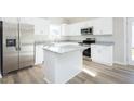 Modern kitchen with stainless steel appliances, white cabinets, and a center island at 160 Tupelo Dr, Spring Hope, NC 27882