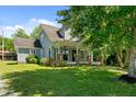 Traditional home boasts a covered porch, brick accents, and a well-manicured lawn at 1661 Reno Sharps Store Rd, Bear Creek, NC 27207
