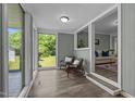 Bright sunroom with large windows, comfortable seating, and serene views of the outdoor landscape at 1661 Reno Sharps Store Rd, Bear Creek, NC 27207