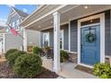 Inviting front porch with rocking chairs, planters, and a blue front door at 168 Amber Acorn Ave, Raleigh, NC 27603
