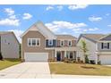 Charming two-story home showcasing a well-manicured front yard and attached two car garage at 170 Creekhaven Dr, Angier, NC 27501