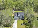 Aerial view shows this property nicely set back from the street with a long driveway and lots of mature trees at 1723 River Club Way, Franklinton, NC 27525