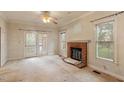 Bright living room with a brick fireplace, windows, and glass doors leading to the outside at 1725 Briarforest Pl, Raleigh, NC 27615