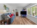 Living room with hardwood flooring, a blue sofa, and a bay window providing natural light at 1805 Holly St, Apex, NC 27502