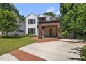 Stunning modern home with white siding, wood accents, and a welcoming red brick driveway at 1820 Park Dr, Raleigh, NC 27605