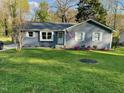 Well-maintained home with green lawn, gray siding, and white trim, plus neatly landscaped flowerbeds at 205 Coachman Dr, Garner, NC 27529