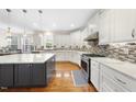 Modern kitchen featuring white cabinets, stainless steel appliances, and a large island at 205 Olive Field Dr, Holly Springs, NC 27540