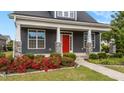 Close up of attractive exterior with gray siding, white trim and bright red front door with stone accent columns at 2057 Big Falls Dr, Wendell, NC 27591